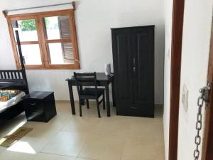 um quarto com uma mesa e cadeiras e um armário preto em Residence Massena, Grand-Popo in Benin em Grand-Popo