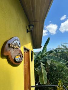 un panneau sur le côté d'un bâtiment jaune dans l'établissement Villas In Sueño Private Jungle Hotel, à Manuel Antonio