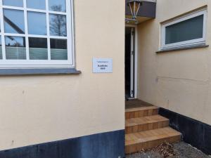 una señal en el lado de una casa con una puerta en Bandholm Bed and Breakfast en Bandholm