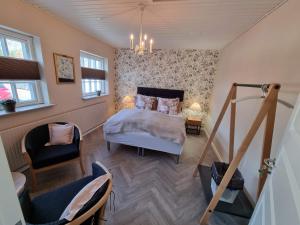 um quarto com uma cama e uma cadeira em Bandholm Bed and Breakfast em Bandholm