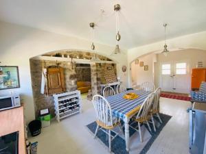 cocina y comedor con mesa y sillas en Cottage with private boat & pool, en Poros