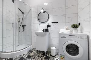 a bathroom with a washing machine and a shower at Wonderful Apartments in the Center of Krakow in Kraków +94 photos