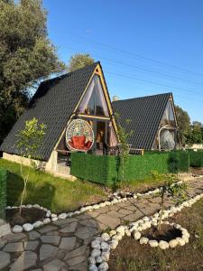 a small house with a black roof and a garden at Brothershomesbungalow in Bahtılı
