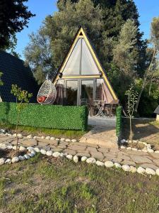 a small house with a large window and a roof at Brothershomesbungalow in Bahtılı