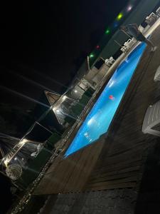 - une piscine bleue ouverte la nuit dans l'établissement Brothershomesbungalow, à Bahtılı