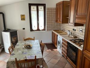 a kitchen with a table and a stove top oven at Bed & Breakfast Il PIGNOMO in Villar Dora