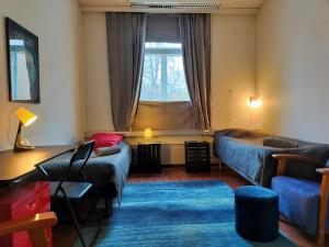 a living room with a bed and a couch and a window at Toimistohotelli Pormestari in Kokkola
