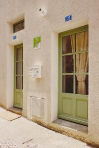 twee groene deuren aan de zijkant van een gebouw bij La Parenthèse in Mortagne-au-Perche