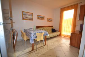 un soggiorno con tavolo, sedie e divano di Villa Poli a Bibione