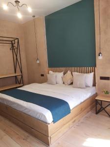 1 dormitorio con 1 cama grande y pared azul en Valley Park Dilijan, en Dilijan