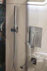 a shower in a bathroom with a glass door at Emily Apartments 2 in Chrysoupolis