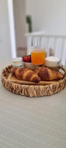 a tray with bread and a glass of orange juice at Casa Brì Boutique Rooms in Santa Teresa Gallura
