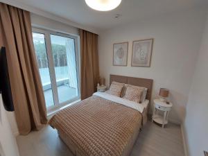 a bedroom with a bed and a large window at Harmony Pearl Apart in Rogowo