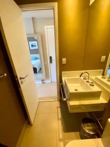 een badkamer met een wastafel, een toilet en een spiegel bij Suíte completa na Barra da Tijuca, Link Stay in Rio de Janeiro
