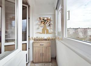 un corridoio con due grandi finestre e un armadietto in legno di Apartament 1 pokój prywatny z prywatną łazienką Gdańsk 1000 m do plaży 2,5 km do Sopotu a Danzica