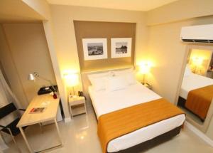 Suíte completa na Barra da Tijuca, Link Stay في ريو دي جانيرو: غرفة الفندق بسرير كبير ومكتب