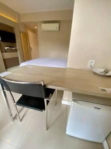 een bureau met een stoel in een kamer met een bed bij Suíte completa na Barra da Tijuca, Link Stay in Rio de Janeiro