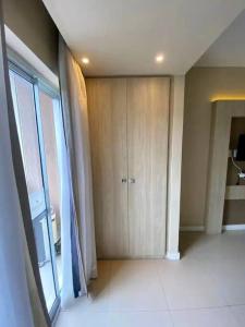 una sala de estar con una gran puerta corredera de cristal en Suíte completa na Barra da Tijuca, Link Stay, en Río de Janeiro