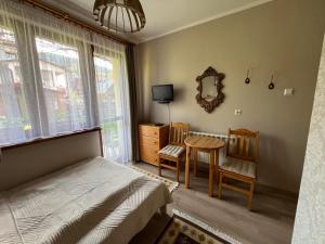 1 dormitorio con 1 cama, mesa y sillas en WYNAJEM POKOI Krościenko Halina Stołowska, en Krościenko nad Dunajcem
