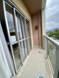 a balcony of a building with large glass windows at Suíte completa na Barra da Tijuca, Link Stay in Rio de Janeiro