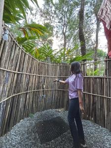 a woman standing next to a wooden fence at Evara by The Offbeat Crew in Idukki