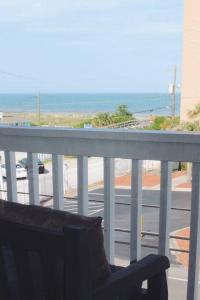 a chair on a balcony with a view of the ocean at Kraken's Den * Oceanview * Steps to ocean * Pool in Carolina Beach