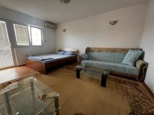 ein Wohnzimmer mit einem Sofa und einem Bett in der Unterkunft Dvosoban kompletno sredjen stan in Tivat