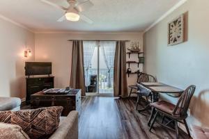 ein Wohnzimmer mit einem Sofa, einem Tisch und einem TV in der Unterkunft Kraken's Den * Oceanview * Steps to ocean * Pool in Carolina Beach