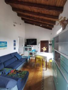 ein Wohnzimmer mit einem blauen Sofa und einem Tisch in der Unterkunft Casetta panoramica Ariccia in Ariccia