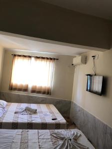 - une chambre avec 2 lits et une fenêtre dans l'établissement Pousadaa São João 144, à Aparecida