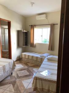 a room with two beds and a window in it at Pousadaa São João 144 in Aparecida