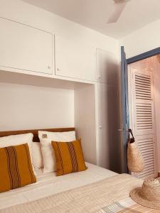 a bedroom with a bed with yellow and white pillows at Attico fronte mare Espardell19 Es Pujols in Es Pujols