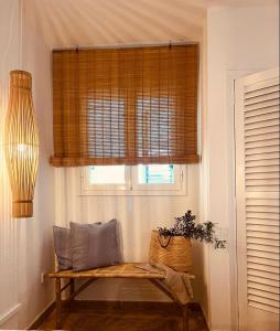 a room with a bench and a window with blinds at Attico fronte mare Espardell19 Es Pujols in Es Pujols