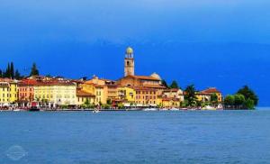 a group of buildings on the shore of a body of water at Appartamento due Pini Lago di Garda in Salò