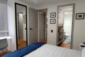 1 dormitorio con cama y baño con espejo. en Wonderful Apartament 7 Floor Viamonti en Medellín