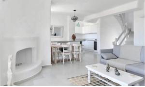 a white living room with a couch and a table at Villa Galano PAROS GREECE in Ambelas