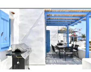 patio ze stołem, krzesłami i sprzętem do grillowania w obiekcie Villa Galano PAROS GREECE w mieście Ambelas
