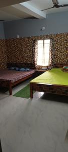 een slaapkamer met 2 bedden en een raam erin bij Pravuprasad Homestay Family Room in Bhubaneshwar