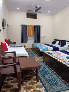 a room with two beds and a table and chairs at Mahadev Kripa sadan Homestay & Guest house in Ayodhya