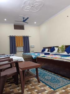 Ayodhya的住宿－Mahadev Kripa sadan Homestay & Guest house，一间设有两张床和一张桌子及椅子的房间