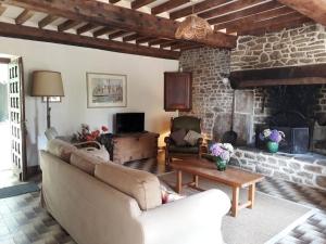 sala de estar con sofá y chimenea en Magnificent French Country House with Private Heated Pool & Gardens, en Quettreville-sur-Sienne