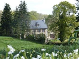 una casa en una colina con un patio con flores en Magnificent French Country House with Private Heated Pool & Gardens, en Quettreville-sur-Sienne