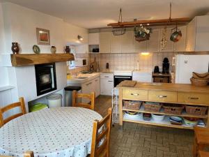 uma cozinha com uma mesa e uma mesa e uma cozinha com em Magnificent French Country House with Private Heated Pool & Gardens em Quettreville-sur-Sienne