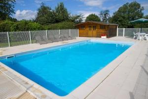 a swimming pool with chairs and a house at Magnificent French Country House with Private Heated Pool & Gardens in Quettreville-sur-Sienne +13 photos