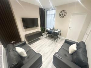 a living room with a couch and a table at Brand New Anfield Home Free Parking, 2 mins from LFC, 15 Mins City Centre in Liverpool