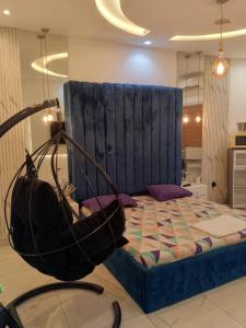 un letto con testiera blu in una stanza di Bénin Booking Buddy a Cotonou