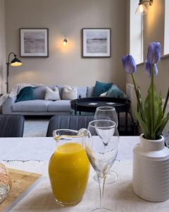 a table with two wine glasses and a vase with flowers at Exceptional Holiday Home 7 in Pickering with Hot Tub in Pickering
