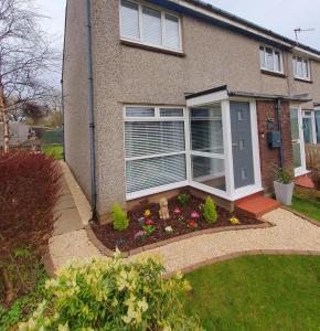 a house with a window and flowers in a garden at Modern 2 Bed in Troon in Loans