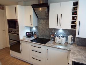 una cocina con armarios blancos y fregadero en Modern 2 Bed in Troon, en Loans