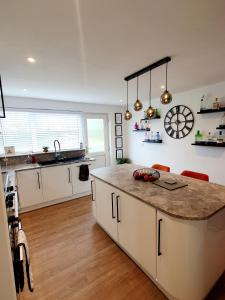a kitchen with white cabinets and a large island at Modern 2 Bed in Troon in Loans